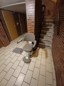 Flow X Treppenlift in Berlin auf einer kurvigen Innentreppe in einem Mehrfamilienhaus